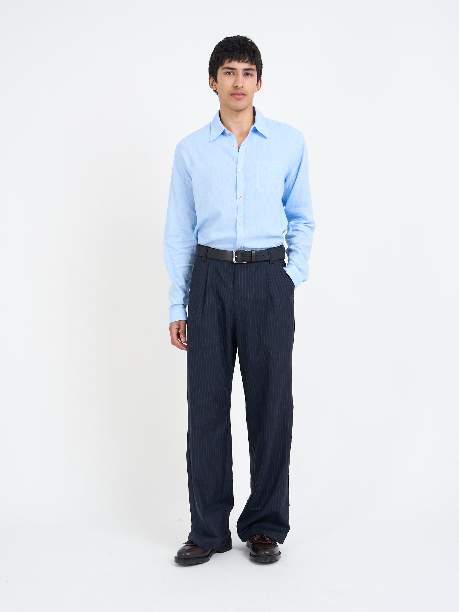Orsman wide-leg navy pinstripe wool trousers worn on model